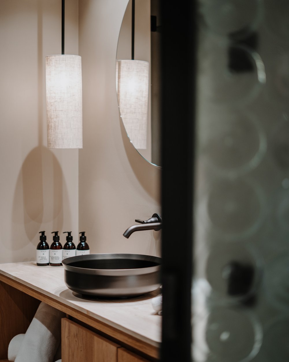 Modernes Badezimmer mit rundem Waschbecken und hängender Lampe