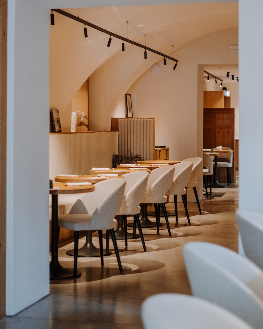 Moderner leerer Restaurantbereich mit beige Stühlen und Holztischen