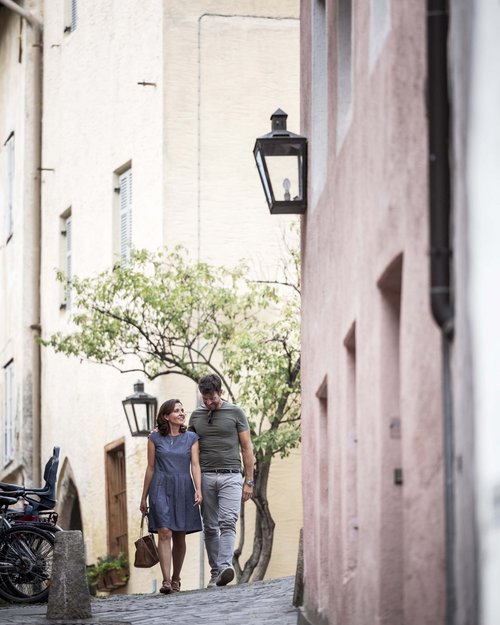 Couple walking down a narrow cobblestone street in a historic town