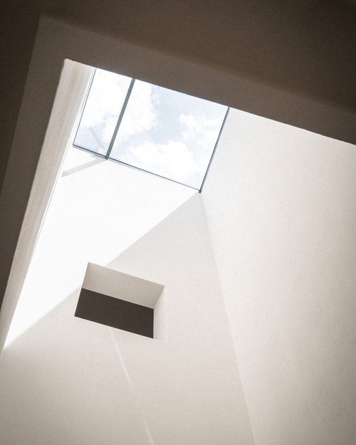Minimalistisches weißes Interieur mit quadratischem Oberlicht und Schatten