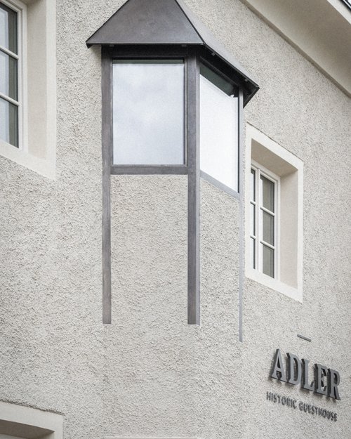 Fassade eines historischen Gästehauses mit Erkerfenster und Adler-Schriftzug